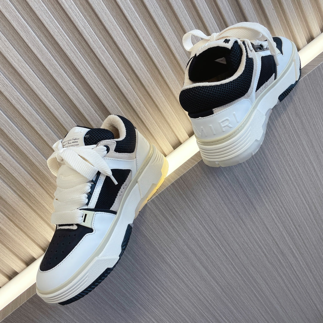 Amiri low-top sneakers with white upper, black heel panels, lace-up and thick sole