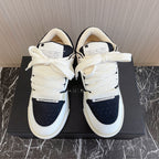 Amiri low-top sneakers, white with black toe panels, tied laces, cushioned tongues