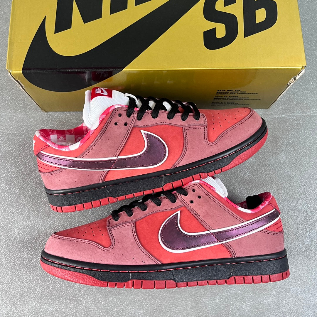 Pair of pink Nike SB Dunk Low sneakers with purple swoosh, black laces, and black sole