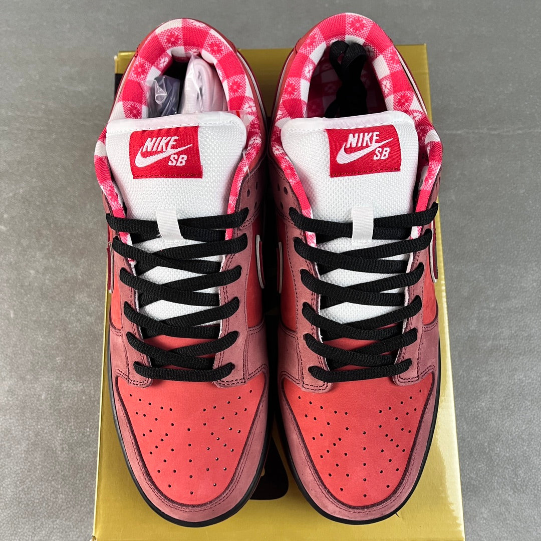 Pink Nike SB Dunk Low sneakers with white tongues labeled Nike SB and black laces