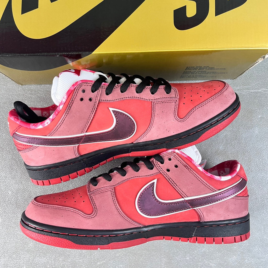 Pink Nike SB Dunk Low sneakers with purple swoosh, black laces, and red-accented sole