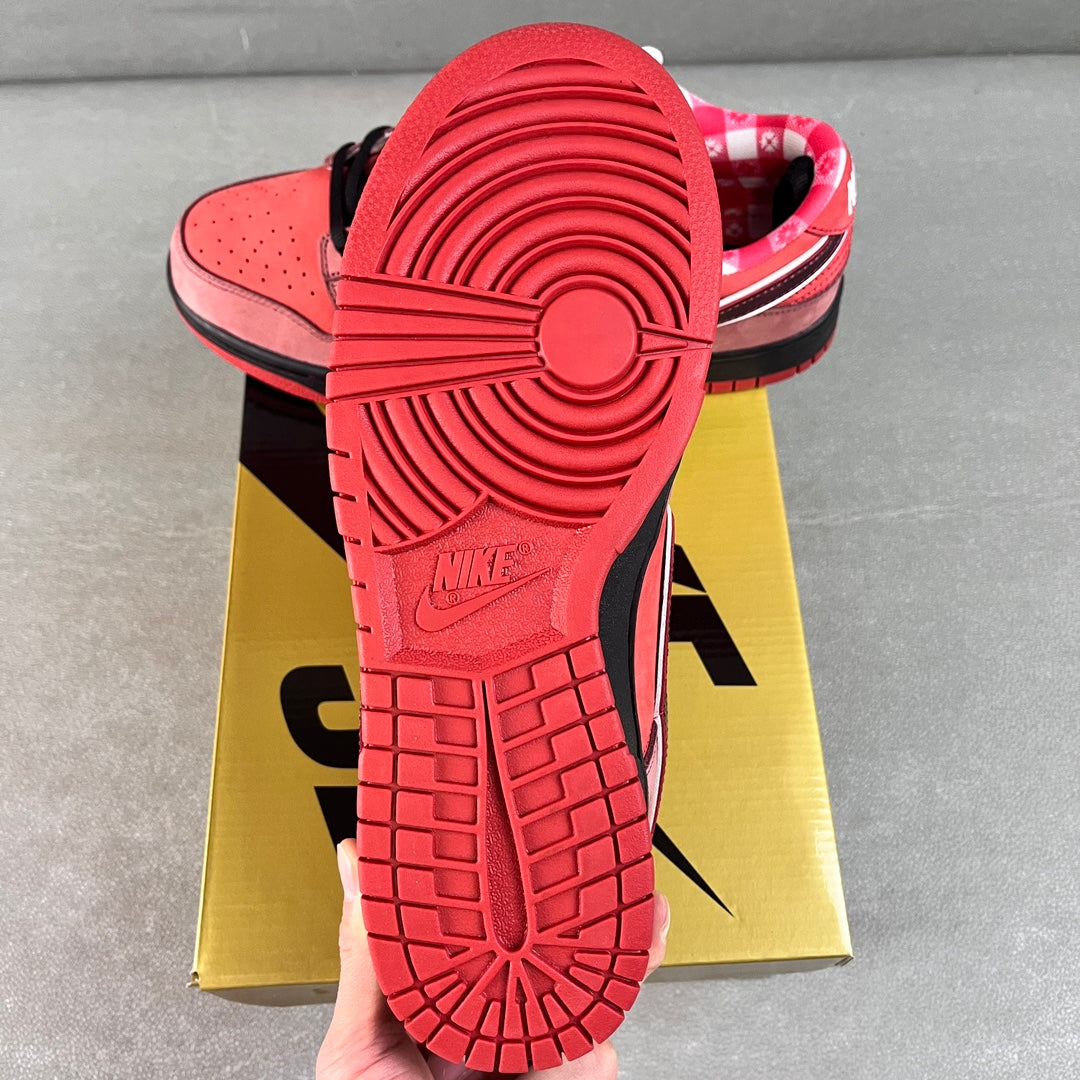 Pink Nike SB Dunk Low sneaker outsole with red traction tread and black midsole
