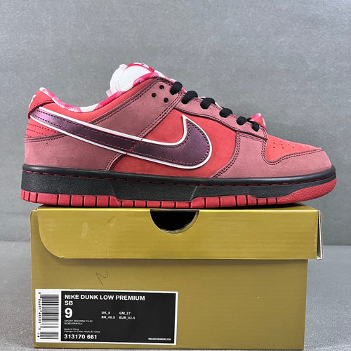 Pink and burgundy Nike SB Dunk Low sneakers with purple swoosh and black laces