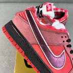 Pink Nike SB Dunk Low sneaker with white-and-purple side stripes, black laces, red sole