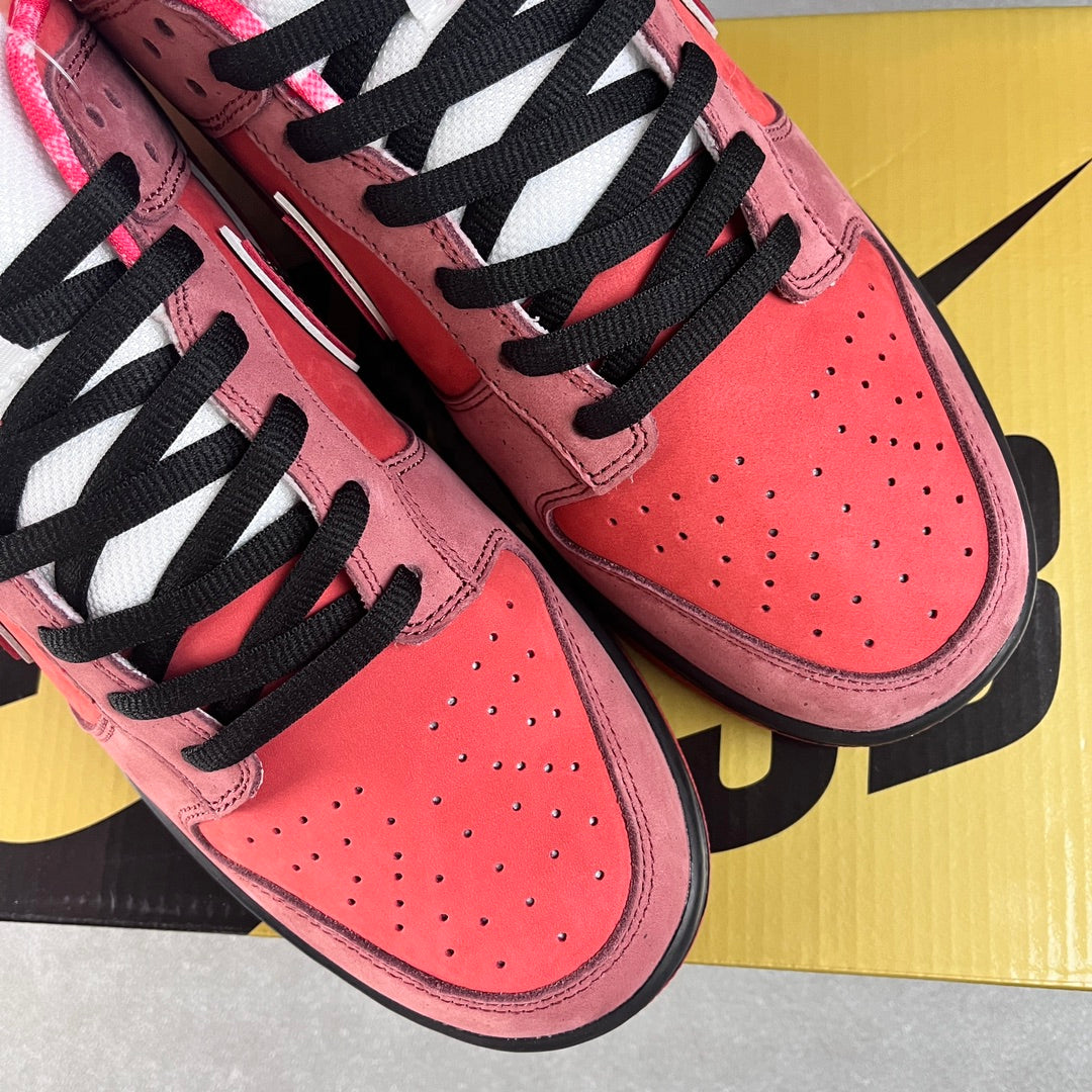 Pink Nike SB Dunk Low sneakers with black laces and perforated toe panels