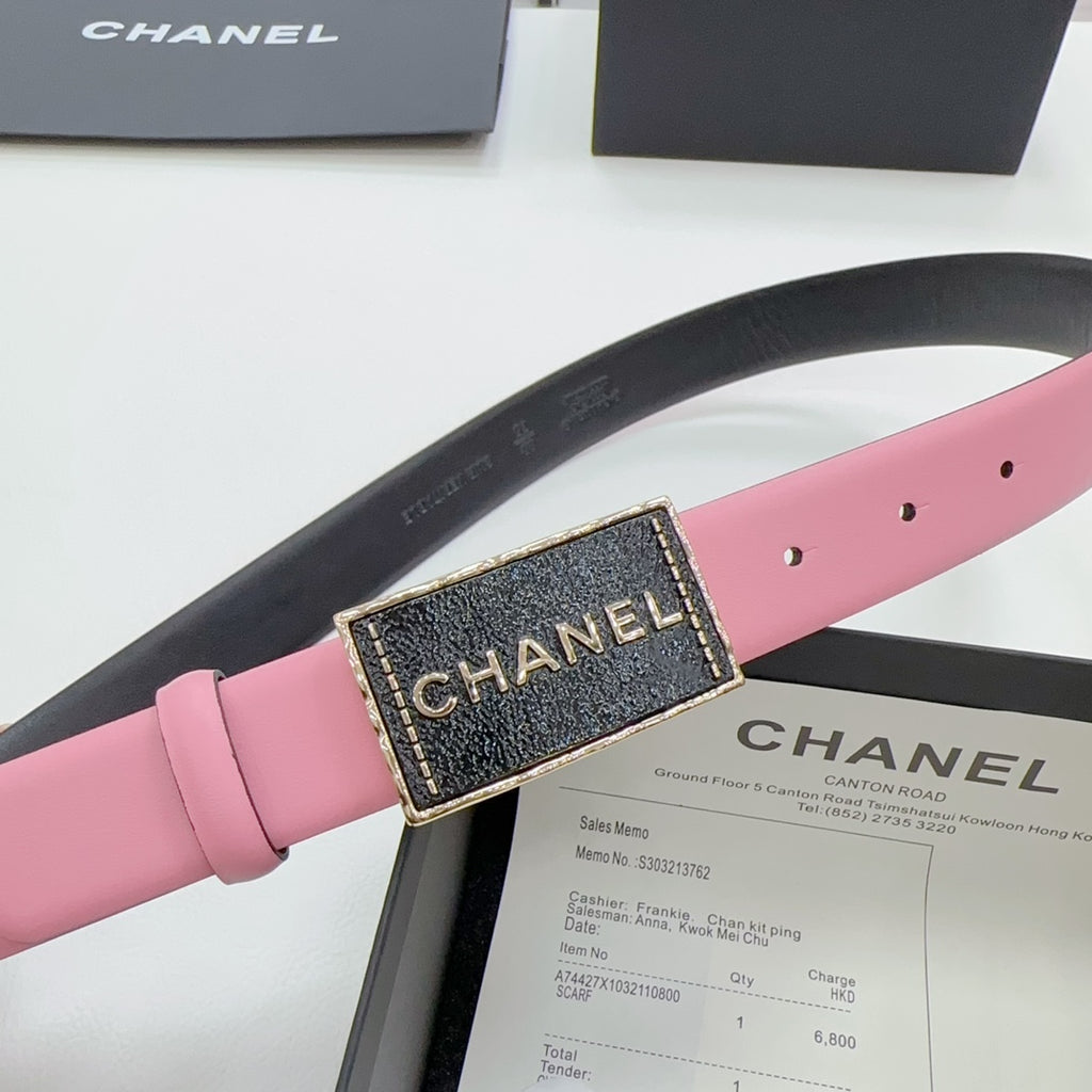Chanel belt buckle close-up on pink strap, black panel with gold CHANEL lettering