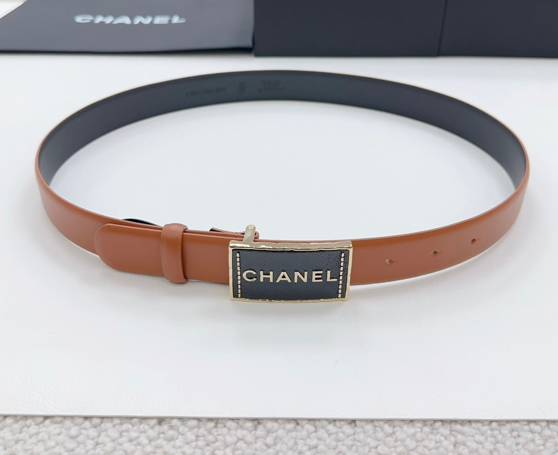 Chanel belt with tan strap and dark gold rectangular logo buckle, laid flat