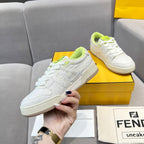White unisex sneakers held in hand; neon green laces and low-profile sole