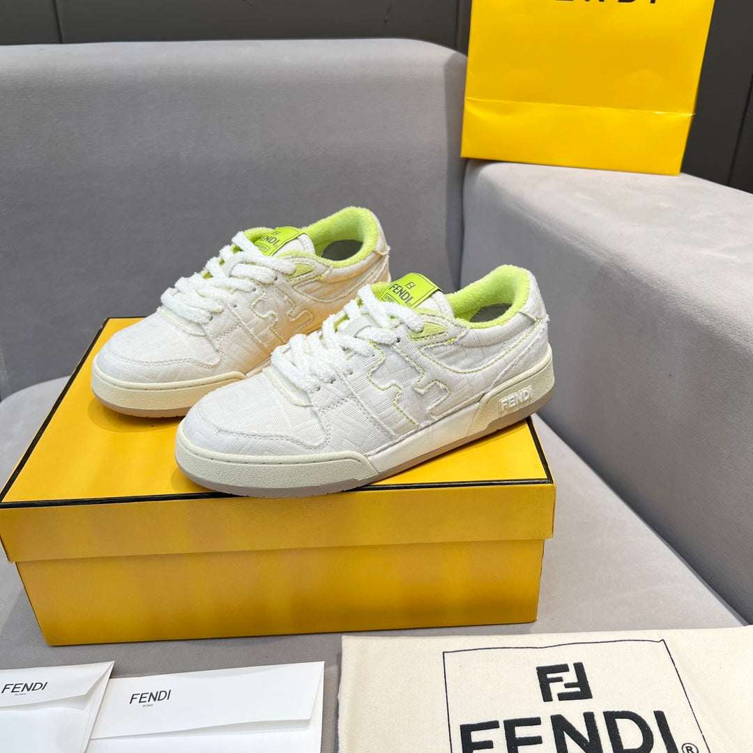White low-top unisex sneakers on box, neon green laces and stitched details