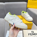 White unisex sneakers on box held by hand; neon green lace accents