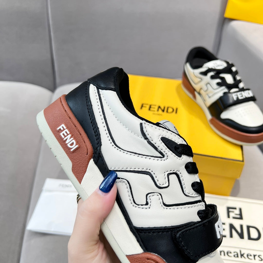 Side view of low-top sneakers with white leather, black overlays, and brown heel panel