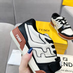 Side view of low-top sneakers with white leather, black overlays, and brown heel panel