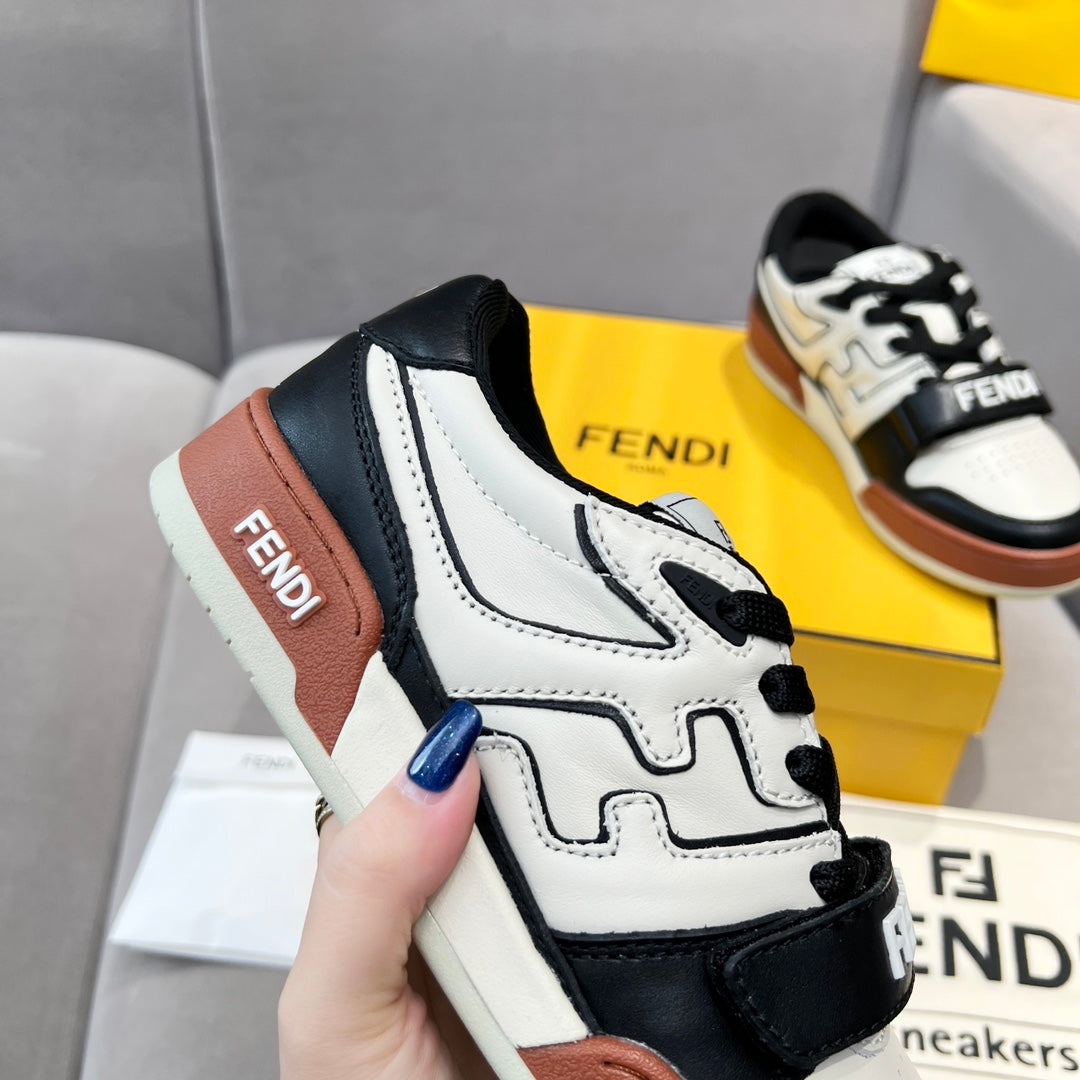 Side view of low-top sneakers with white leather, black overlays, and brown heel panel