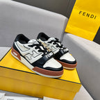 Low-top sneakers with white leather, black panels, brown sole, and lace-up design