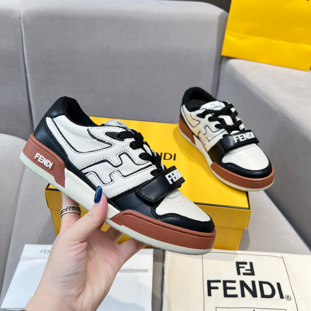 Pair of low-top sneakers in white, black, and brown with lace-up and logo strap
