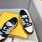 Front view of white and black low-top sneakers with lace-up straps and brown soles