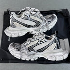White Balenciaga-style chunky sneakers with black stripe details and lace-up uppers