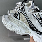 White chunky sneakers with black side stripes, mesh panels, and lace-up closure