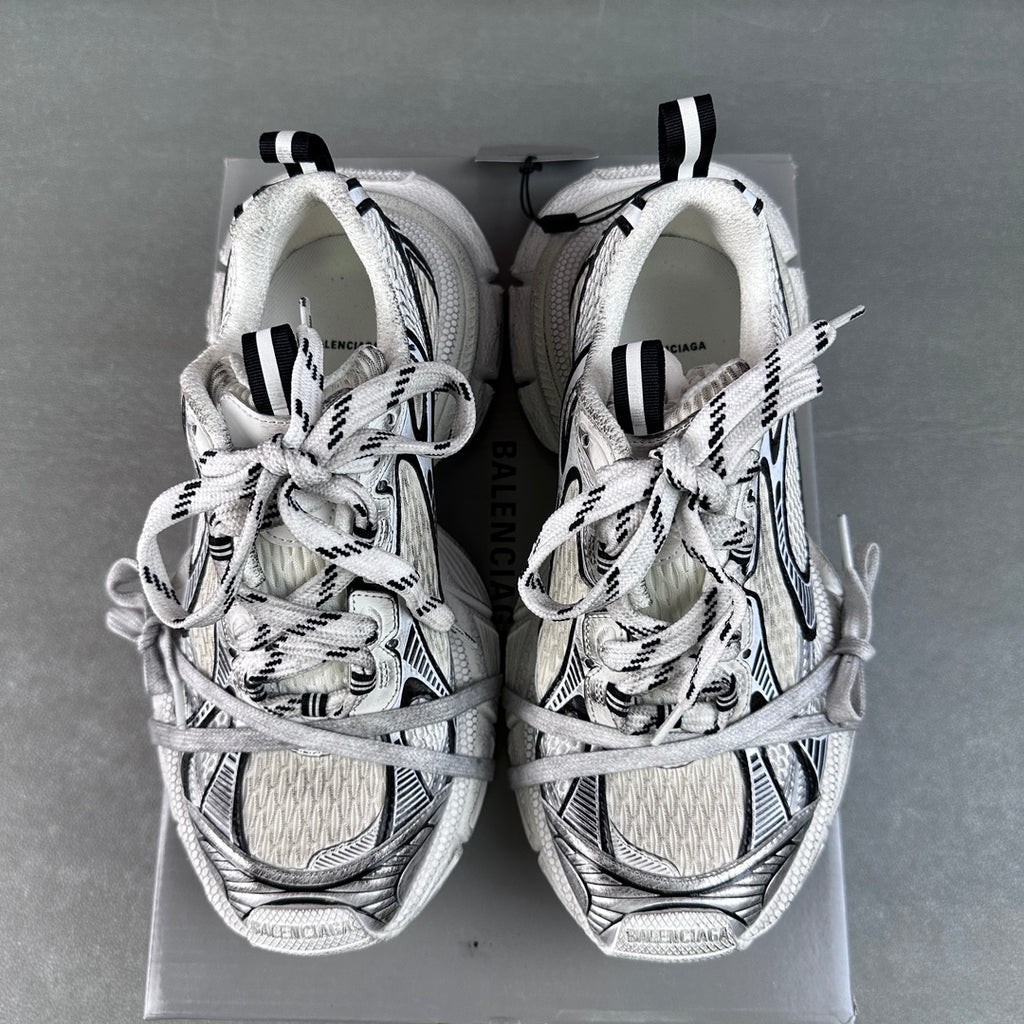 Pair of white lace-up sneakers with black accents and patterned toe caps