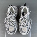 Pair of white lace-up sneakers with black accents and patterned toe caps