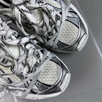 White lace-up sneakers with black trim, showing textured upper and sole tread
