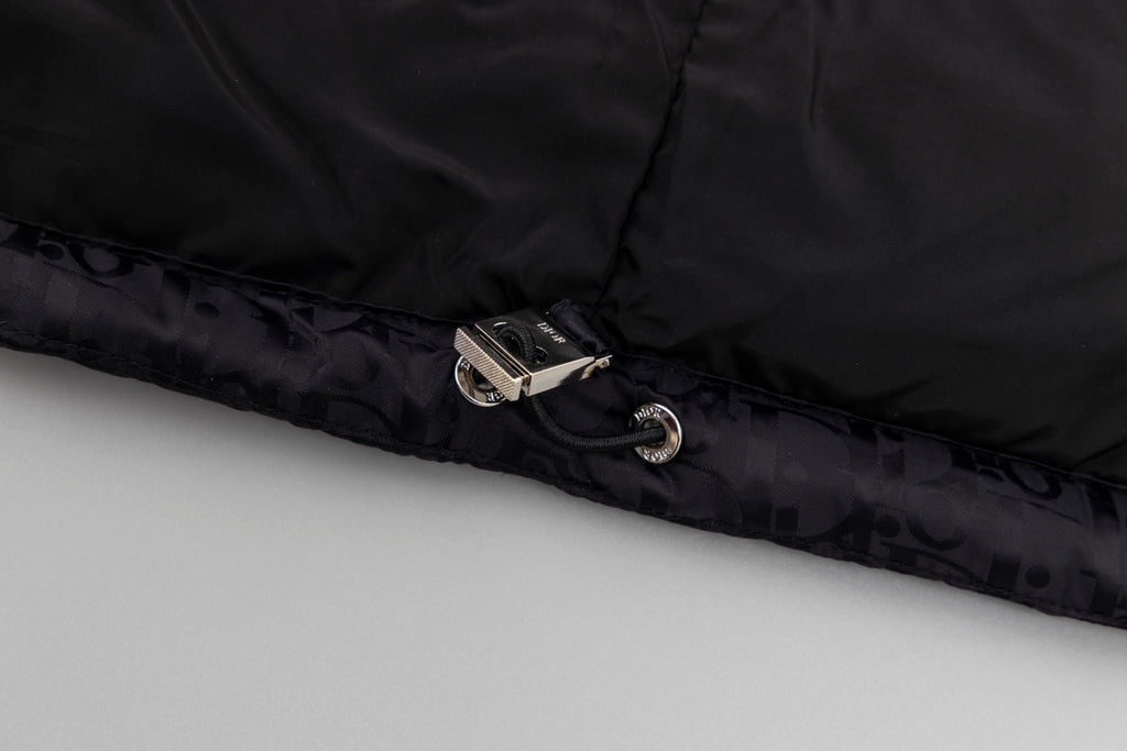 Black hooded puffer vest hem with snap closure and metal hardware