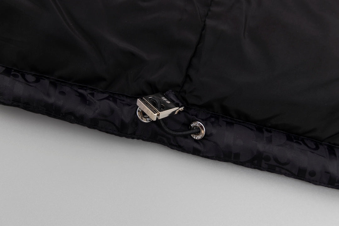 Black hooded puffer vest hem with snap closure and metal hardware