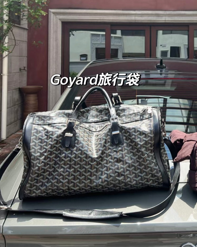 Patterned duffel bag with black leather handles, dual top zippers, shoulder strap