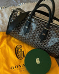 Goyard patterned duffel bag with black leather handles and top zippers