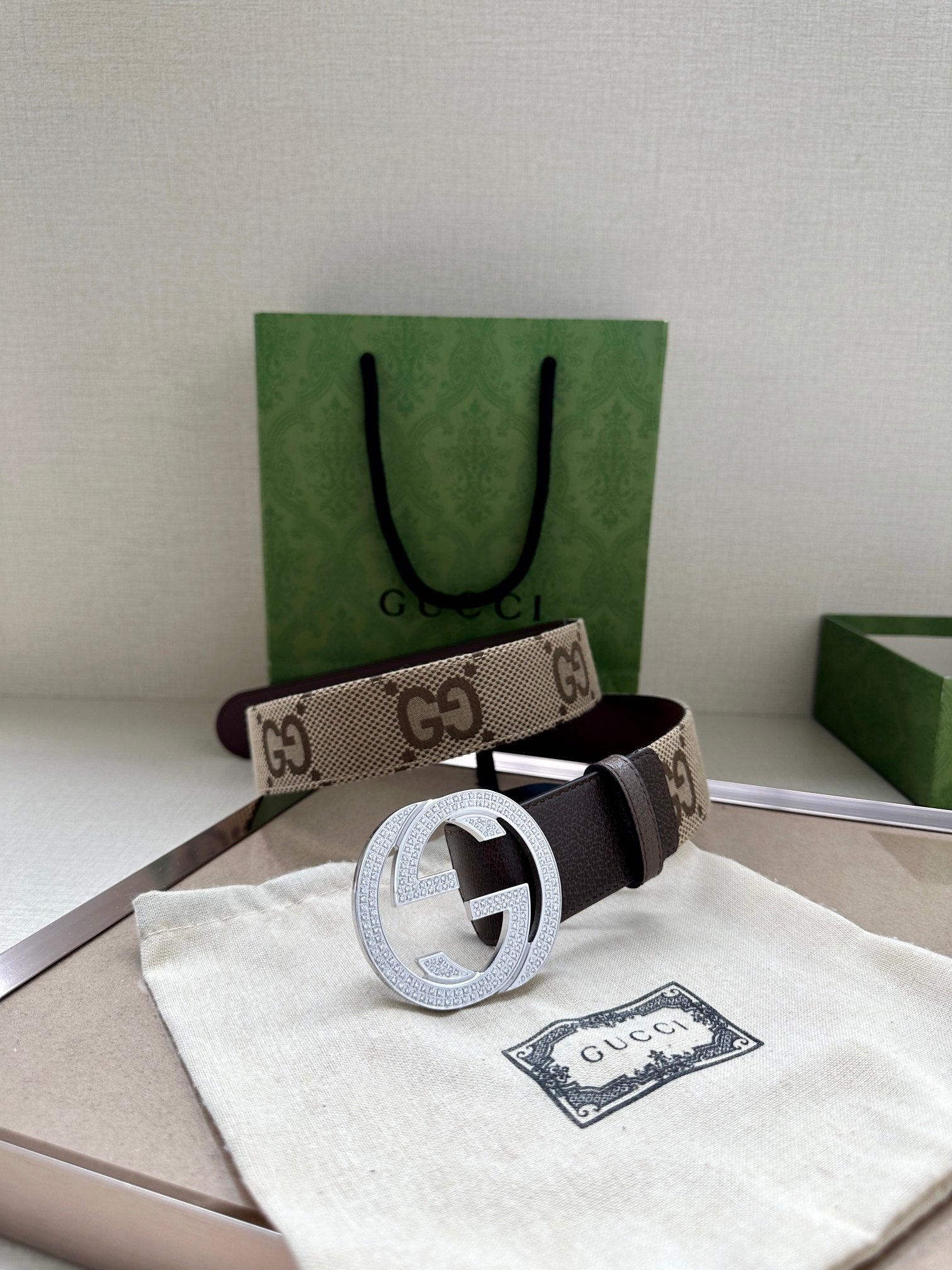 Gucci belt with GG canvas band and dark strap, featuring circular G buckle