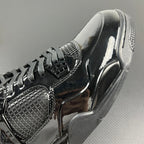 Black Air Jordan 4 upper close-up with mesh quarter panel and lace eyelets.