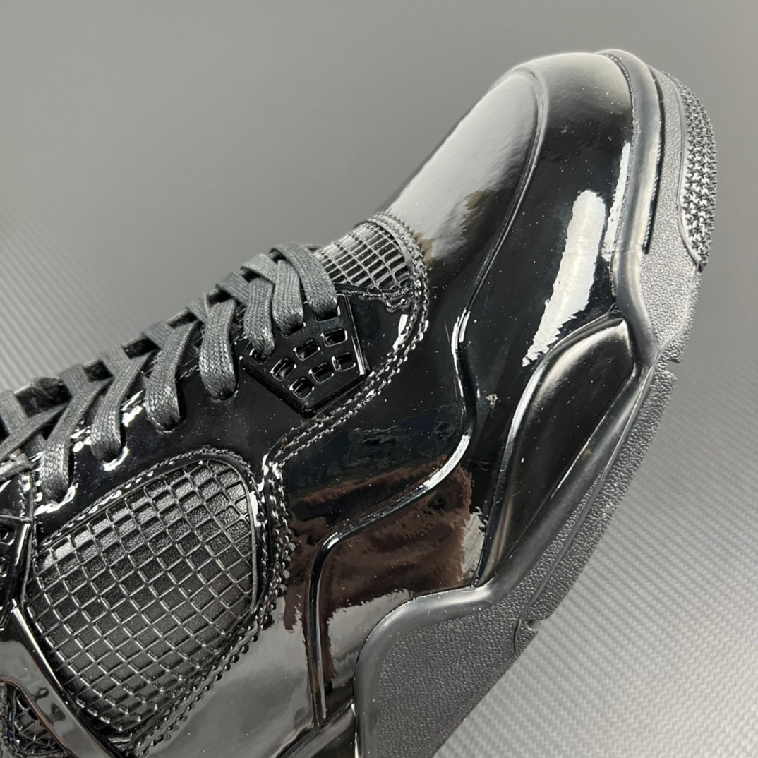 Black Air Jordan 4 upper close-up with mesh quarter panel and lace eyelets.