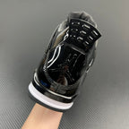 Black Air Jordan 4 sneaker, glossy toe cap, metal lace hooks, white midsole.