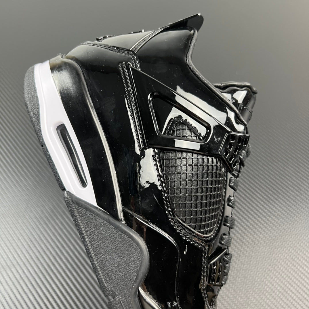 Black Air Jordan 4 sneaker with side cage and white-striped midsole.