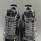 Two black Air Jordan 4 sneakers, lace-up uppers with mesh and patent panels.