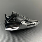 Black Air Jordan 4 sneaker, patent leather panels, mesh detail, lace-up.