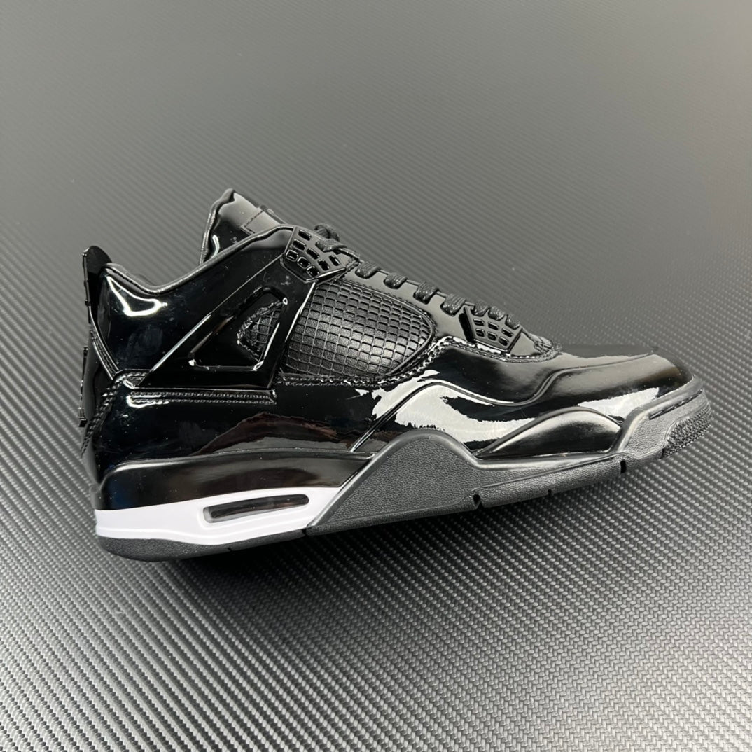 Black Air Jordan 4 sneaker, patent leather panels, mesh detail, lace-up.