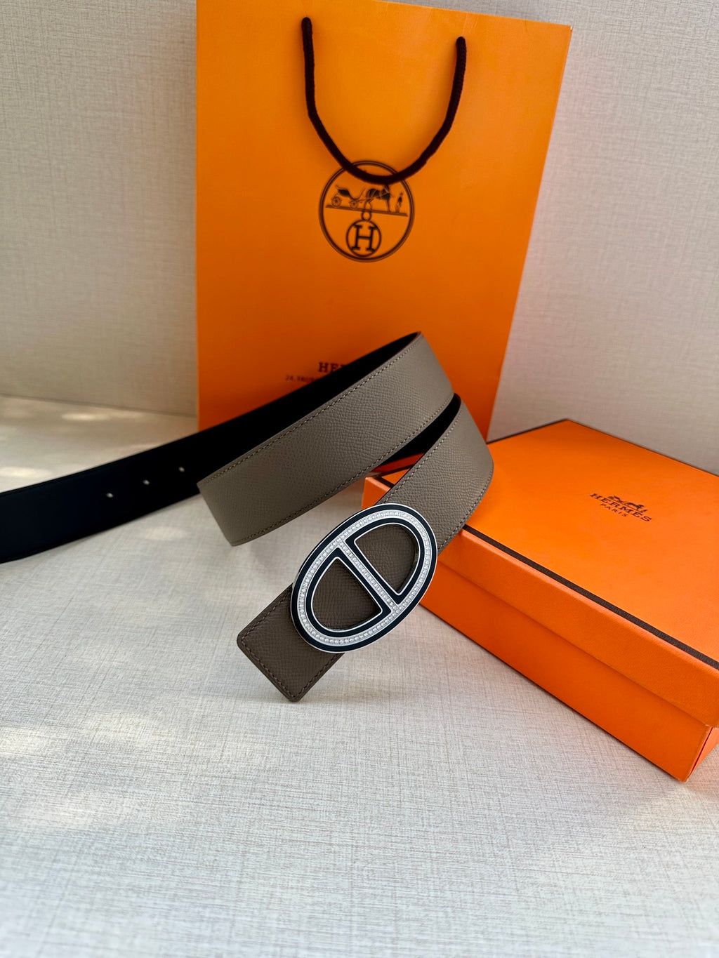 Grey belt with oval interlocking buckle and visible strap holes