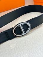 Black leather belt close-up with silver-toned double “H” buckle centerpiece on strap.