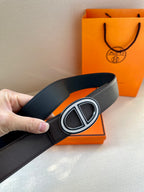 Black belt with textured strap and silver double-H buckle, close-up
