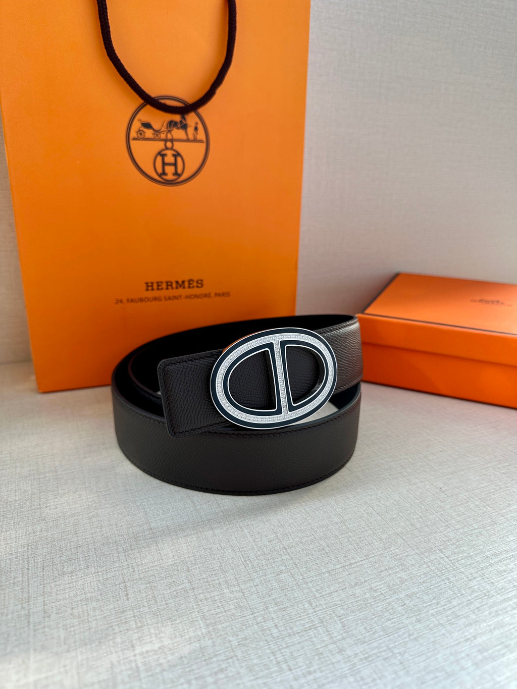 Black leather belt with silver double-H buckle, lying flat