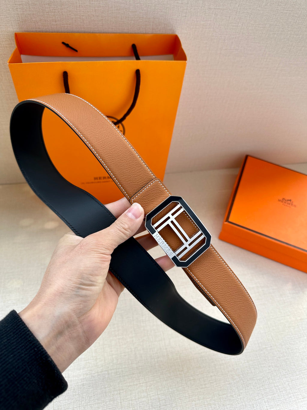 Tan leather belt with black reverse and silver-tone H square buckle