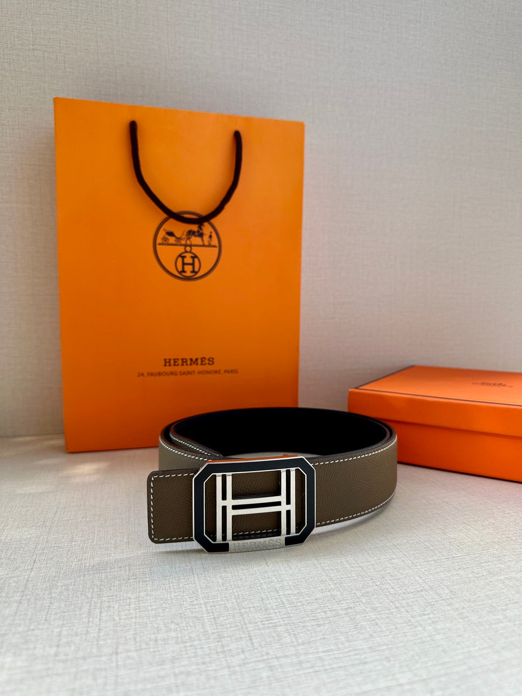 Dark gray leather belt with silver Hermes buckle, laid flat