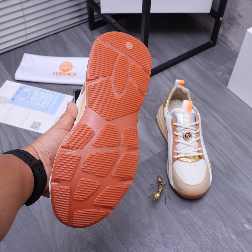 Versace sneaker outsole view: orange rubber tread sole and white shoe upper