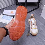 Versace sneaker outsole view: orange rubber tread sole and white shoe upper