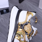 Versace luxury sneakers side view, white panels with gold trim and blue patterned section