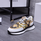 Versace luxury sneakers with gold-and-blue patterned uppers, white sides, black sole