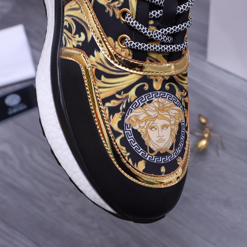 Versace luxury shoes, close-up black slip-on sneakers with gold medallion face print and chain