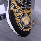 Versace luxury shoes, close-up black slip-on sneakers with gold medallion face print and chain