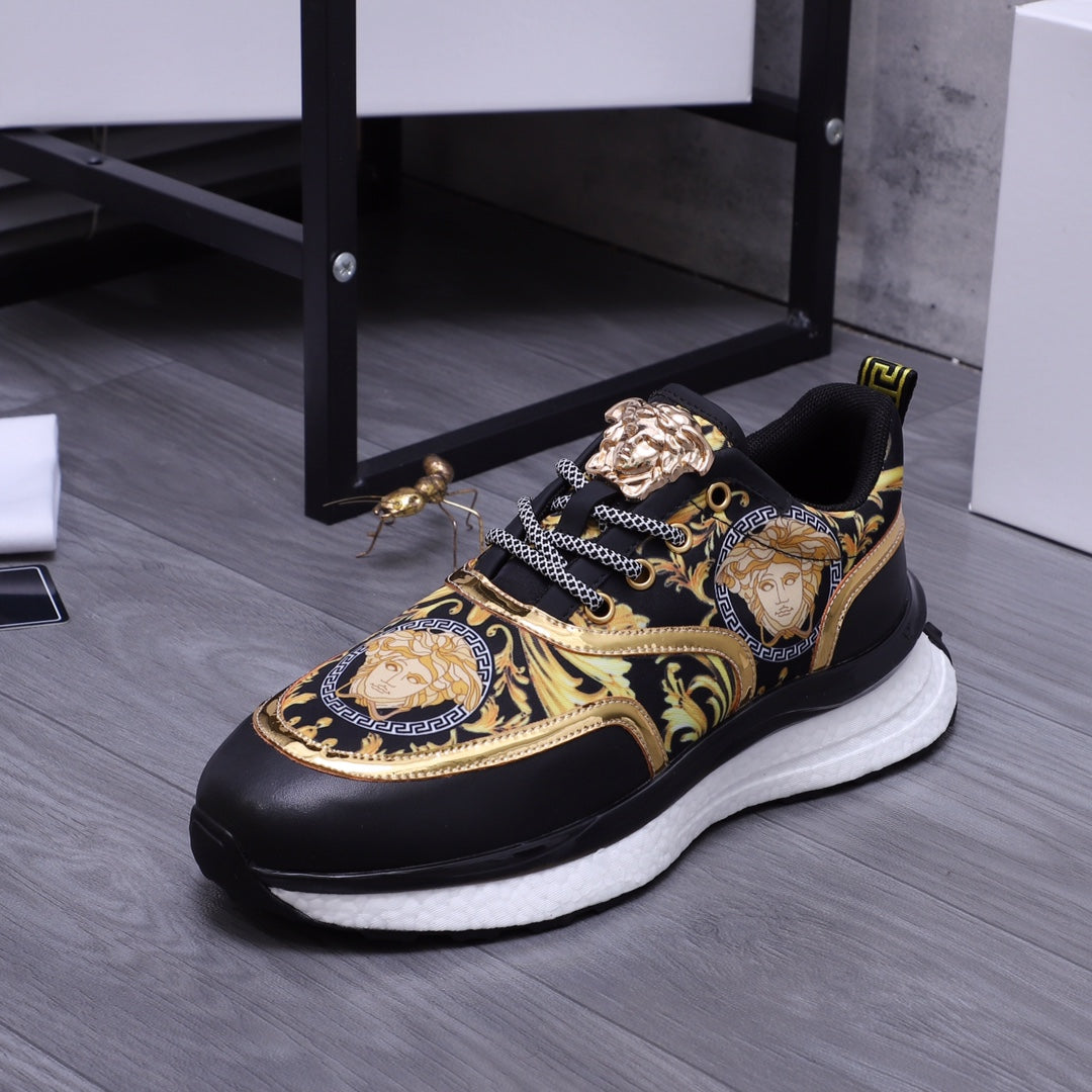 Versace luxury shoes, front view black sneakers with gold ornate panels and chunky white sole